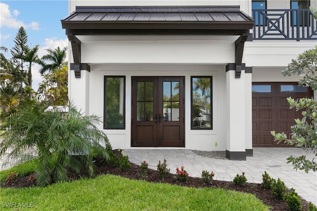 27570 Tarpon Way, Bonita Springs, FL 34134 - property entrance featuring a standing seam roof, french doors, metal roof, stucco siding, and a balcony