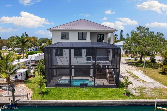 back of house featuring a yard, a patio area, and a lanai