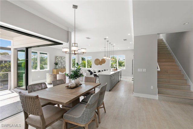 dining room with light hardwood / wood-style floors, a notable chandelier, and a wealth of natural light