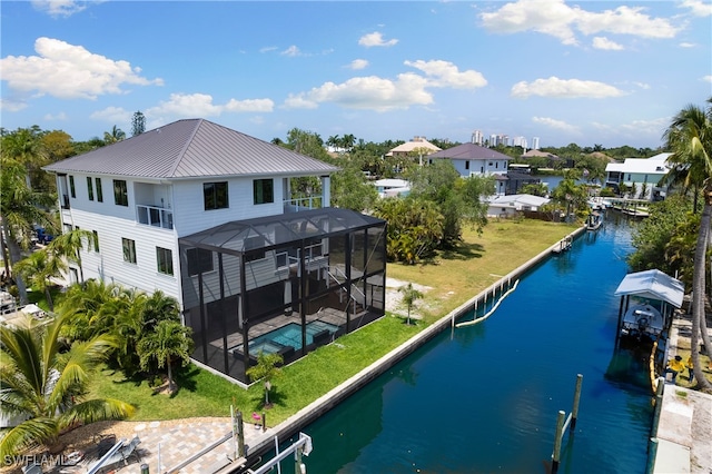 exterior space with a patio, a yard, a water view, and glass enclosure