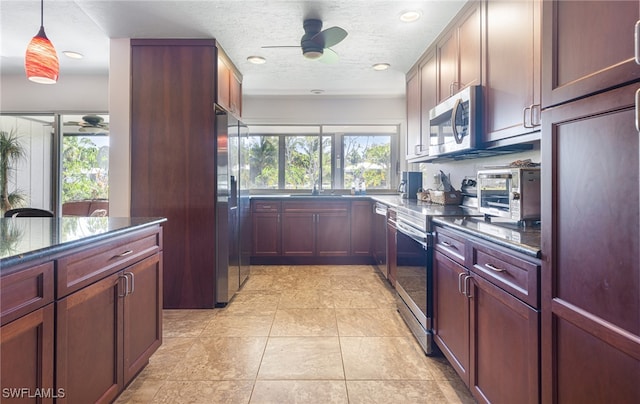 kitchen featuring sink, appliances with stainless steel finishes, ceiling fan, a textured ceiling, and hanging light fixtures