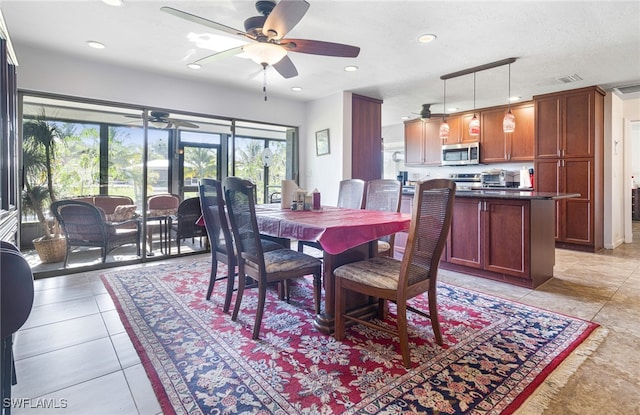 tiled dining space with ceiling fan