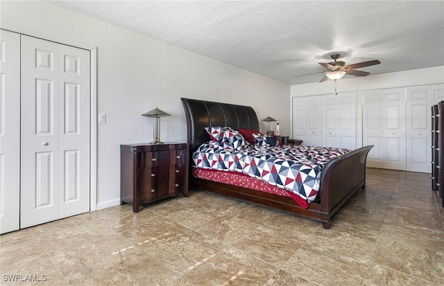 bedroom featuring ceiling fan, a textured ceiling, and multiple closets