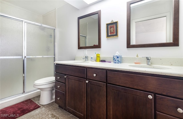 bathroom featuring a shower with shower door, vanity, toilet, and tile patterned flooring