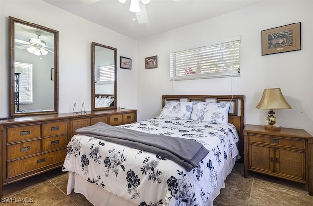 bedroom with ceiling fan and dark tile patterned flooring