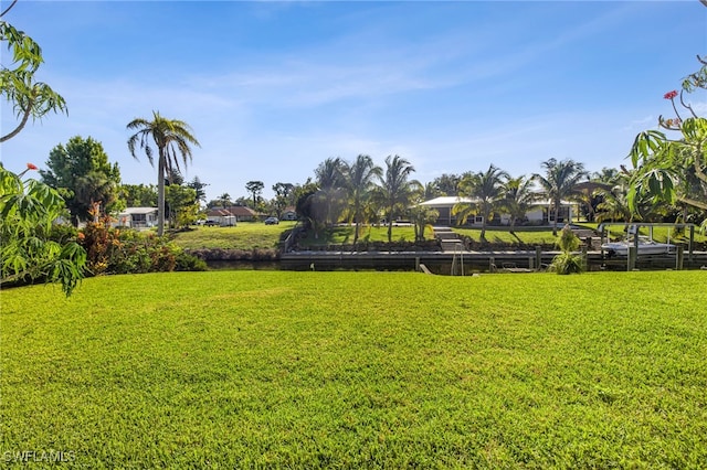 view of property's community with a water view and a lawn