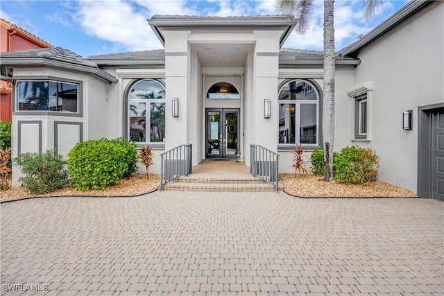 entrance to property featuring a tile roof and stucco siding