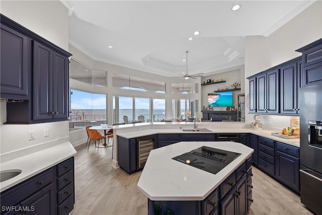 kitchen featuring a peninsula, a kitchen island, refrigerator with ice dispenser, and black electric cooktop