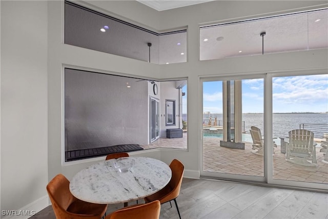 dining space featuring a water view and baseboards