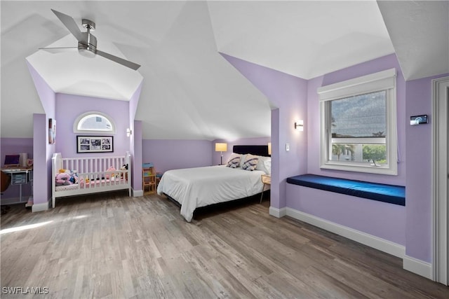 bedroom featuring ceiling fan, vaulted ceiling, baseboards, and wood finished floors