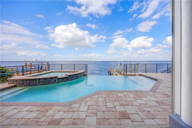 view of pool featuring a water view, a pool with connected hot tub, and a patio