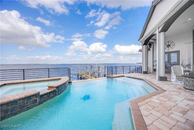 view of pool with a pool with connected hot tub, a water view, and a patio