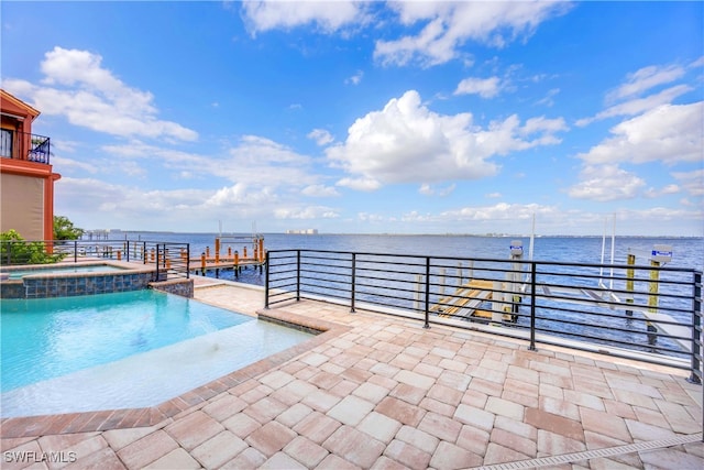 view of swimming pool with a water view, a patio area, and a pool with connected hot tub