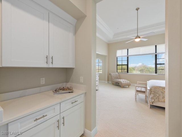 kitchen featuring light carpet, crown molding, white cabinets, and ceiling fan