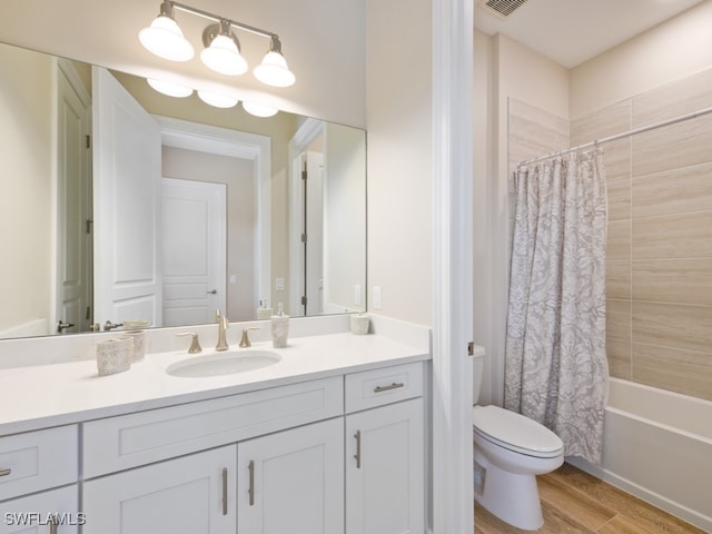 full bathroom featuring hardwood / wood-style floors, vanity, toilet, and shower / tub combo