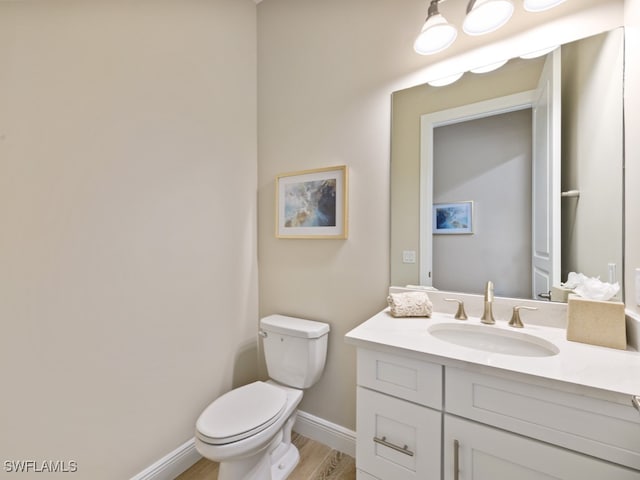 bathroom featuring hardwood / wood-style floors, vanity, and toilet