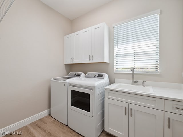 washroom featuring cabinets, separate washer and dryer, light hardwood / wood-style flooring, and sink