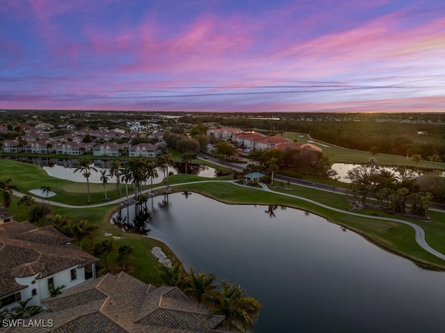 aerial view at dusk featuring a water view