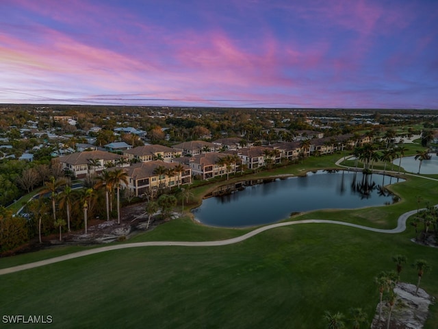 aerial view at dusk featuring a water view