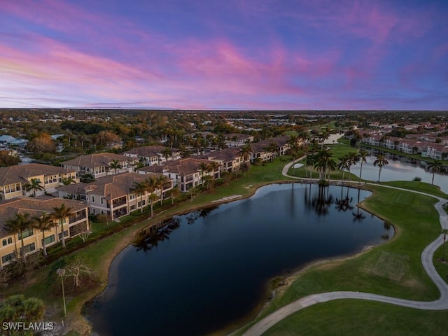 aerial view at dusk featuring a water view