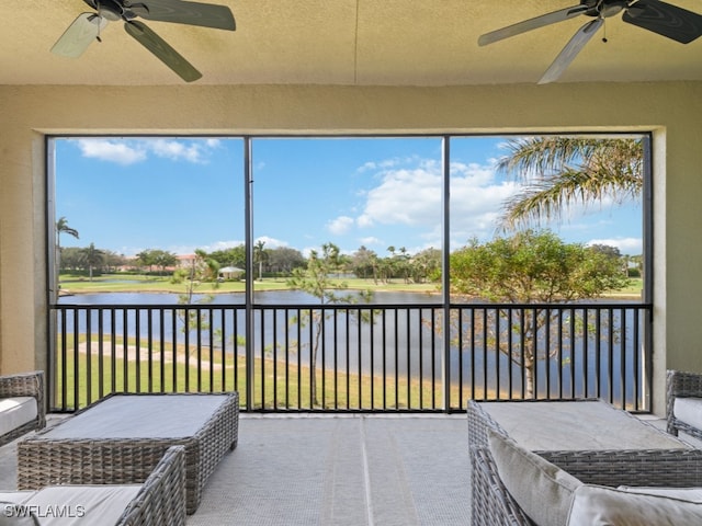 unfurnished sunroom with a water view and ceiling fan