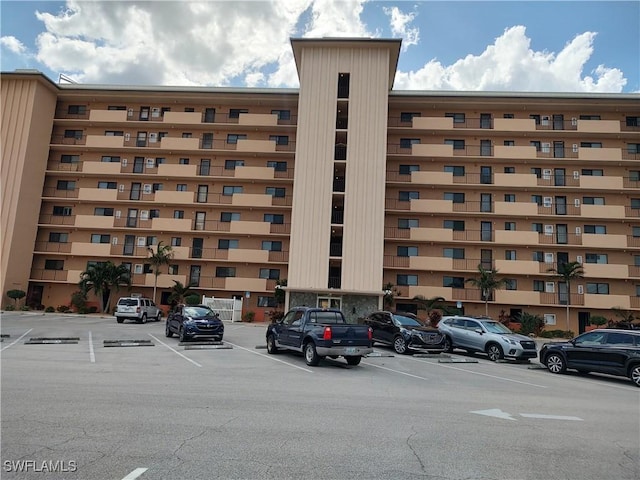 view of building exterior with uncovered parking