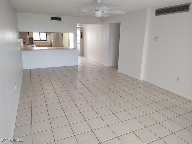 unfurnished living room with ceiling fan and light tile patterned floors