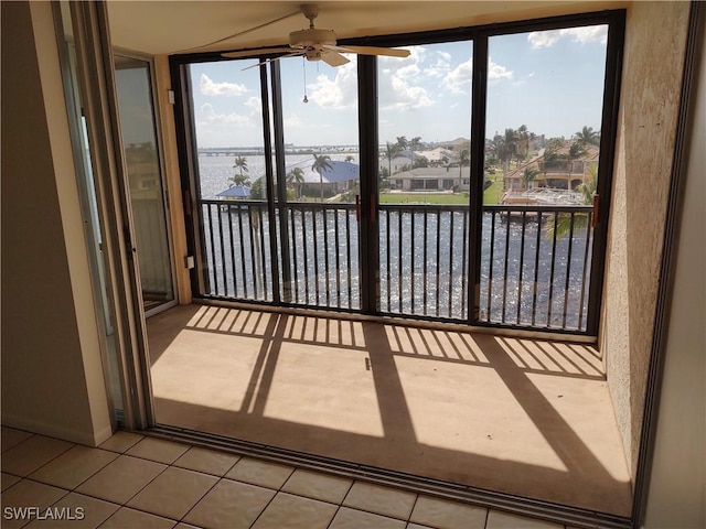 unfurnished sunroom with a water view and ceiling fan