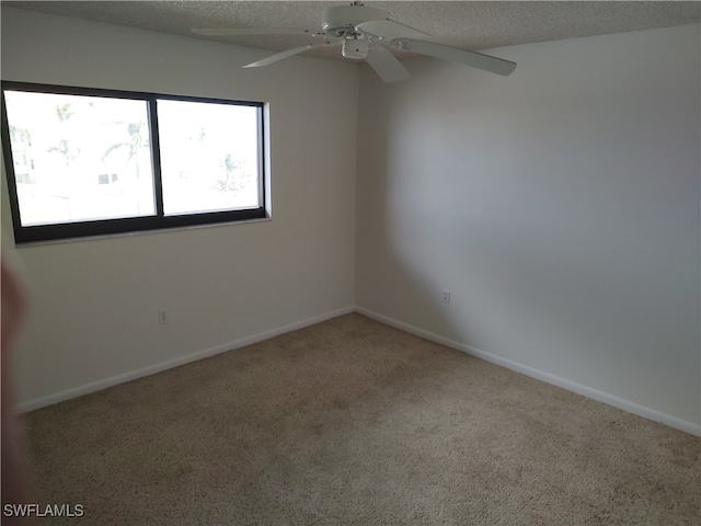 spare room featuring carpet, a textured ceiling, and ceiling fan