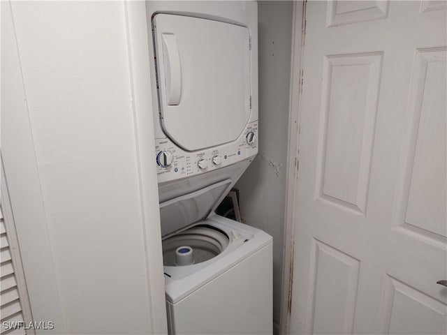 clothes washing area featuring stacked washing maching and dryer