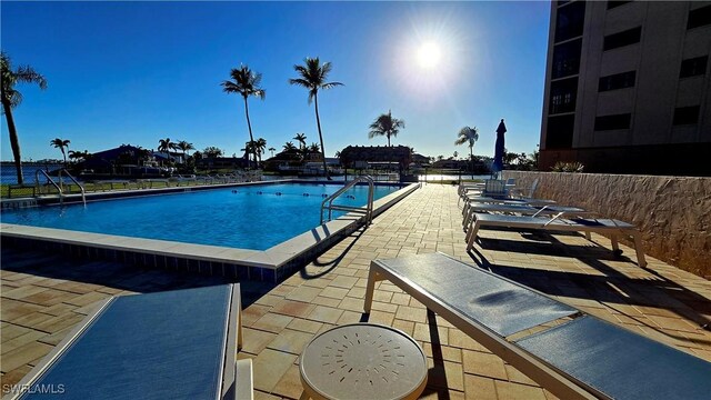 pool featuring fence and a patio area