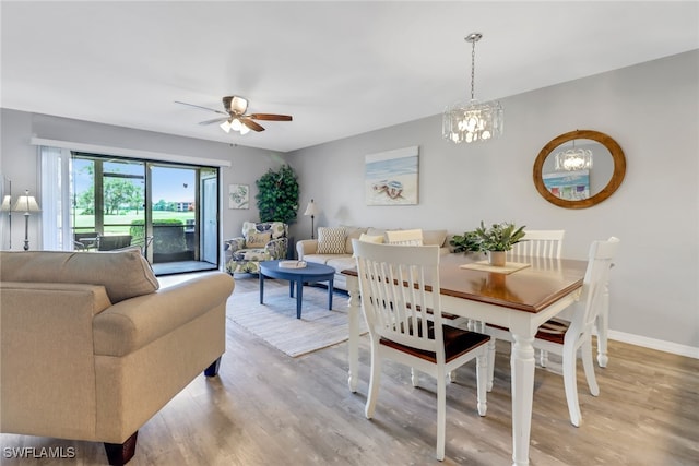 dining area featuring hardwood / wood-style flooring and ceiling fan with notable chandelier