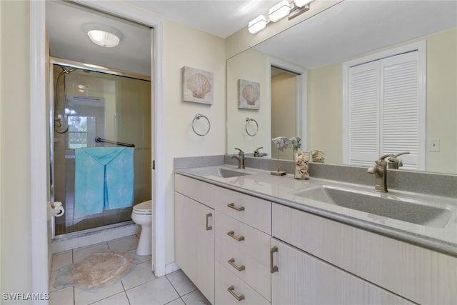 bathroom with toilet, vanity, tile patterned floors, and walk in shower