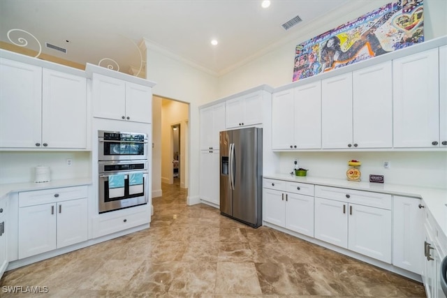 kitchen with appliances with stainless steel finishes, crown molding, and white cabinetry