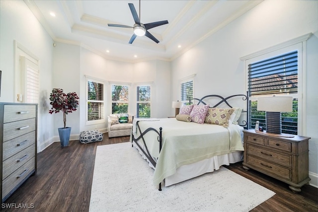 bedroom featuring ceiling fan, a tray ceiling, dark hardwood / wood-style flooring, and crown molding