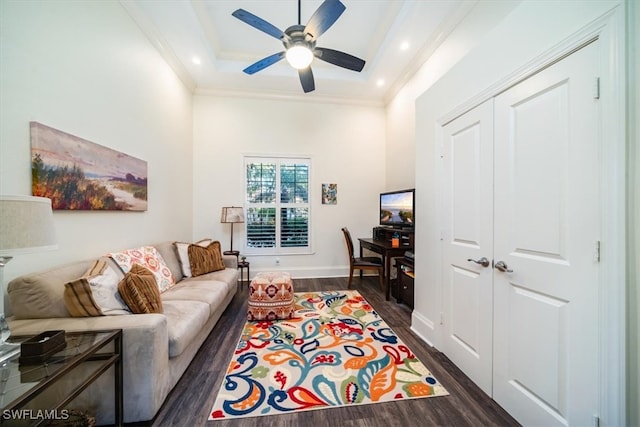 living room with ornamental molding, ceiling fan, a tray ceiling, and dark hardwood / wood-style flooring