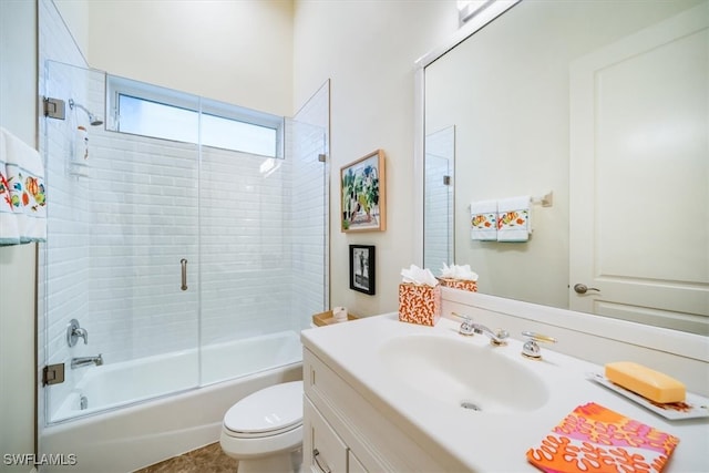 full bathroom featuring vanity, toilet, and shower / bath combination with glass door