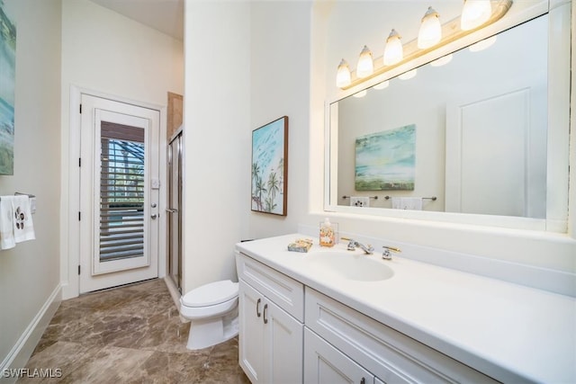 bathroom featuring vanity, toilet, and an enclosed shower