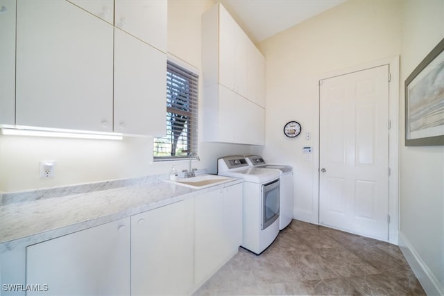 laundry area featuring sink, washing machine and dryer, and cabinets