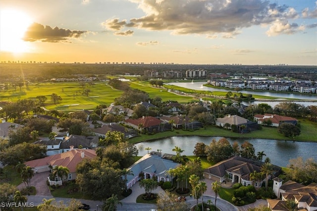 aerial view at dusk featuring a water view