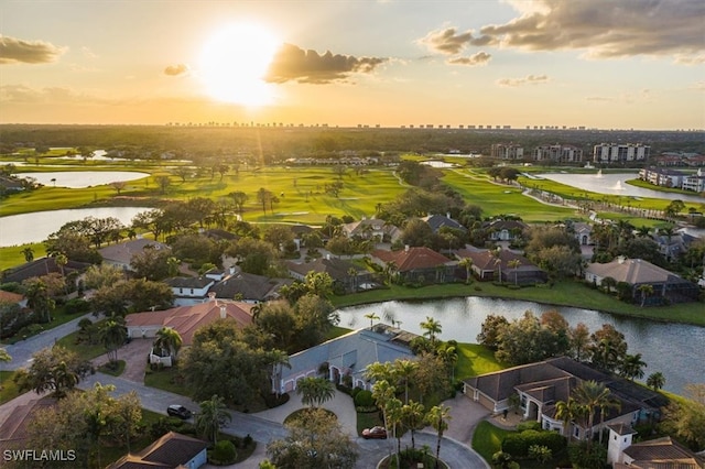 aerial view at dusk featuring a water view