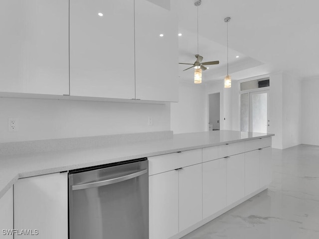 kitchen featuring stainless steel dishwasher, a raised ceiling, ceiling fan, pendant lighting, and white cabinets