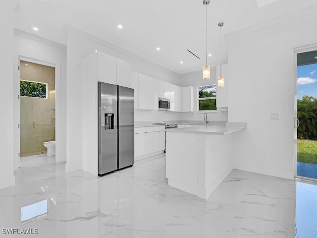 kitchen with kitchen peninsula, stainless steel appliances, sink, decorative light fixtures, and white cabinetry