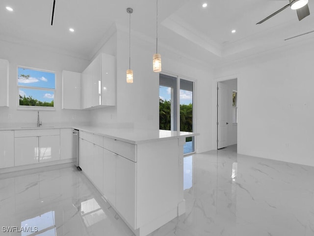 kitchen with kitchen peninsula, ceiling fan, sink, white cabinets, and hanging light fixtures