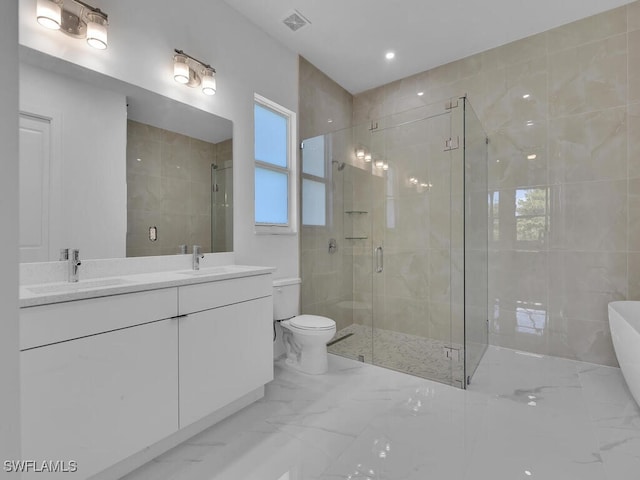 bathroom featuring vanity, a shower with shower door, and toilet