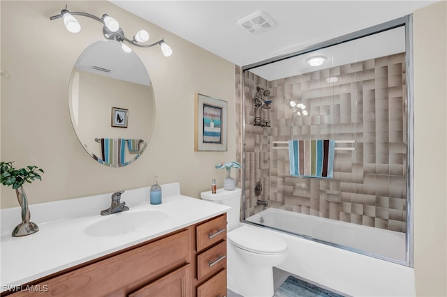 full bathroom featuring vanity, bath / shower combo with glass door, and toilet