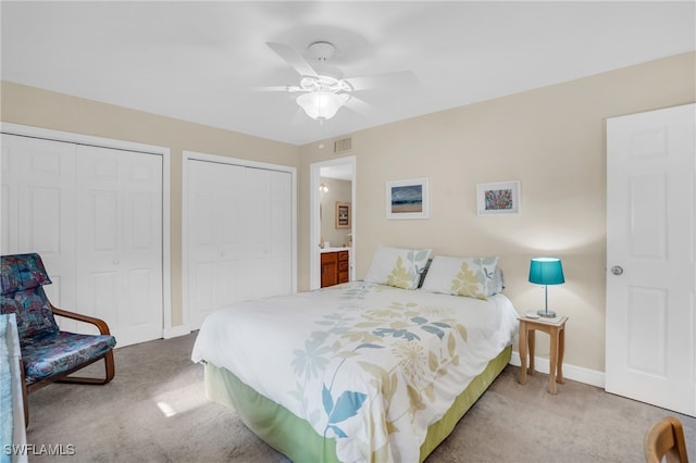 carpeted bedroom featuring ceiling fan and two closets