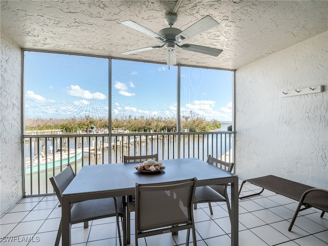 sunroom with a water view and ceiling fan