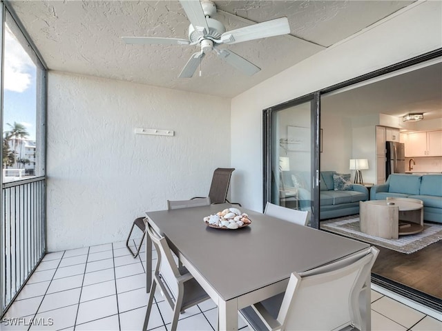 dining space featuring light tile patterned floors, a textured ceiling, and a textured wall