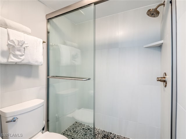 bathroom with an enclosed shower and toilet